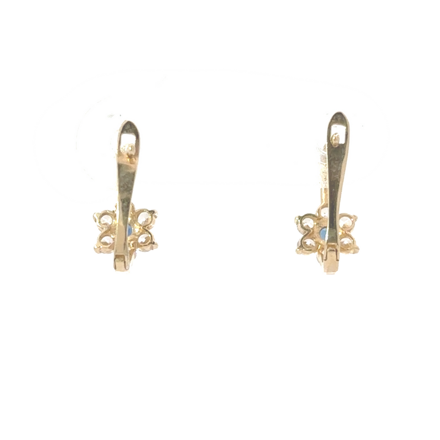 14K gold flower earrings with cubic zirconia displayed on a soft fabric