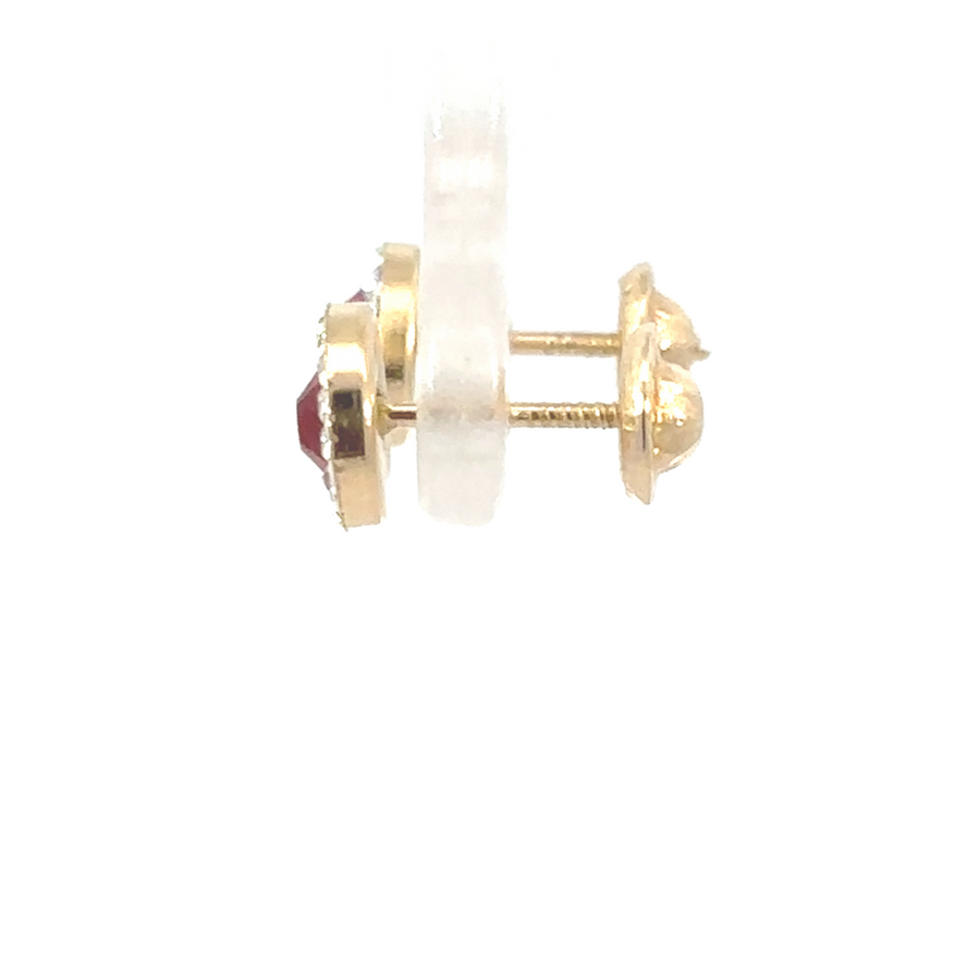 14K gold stud earrings displayed on a velvet surface, showcasing their sleek design and vibrant red stone.