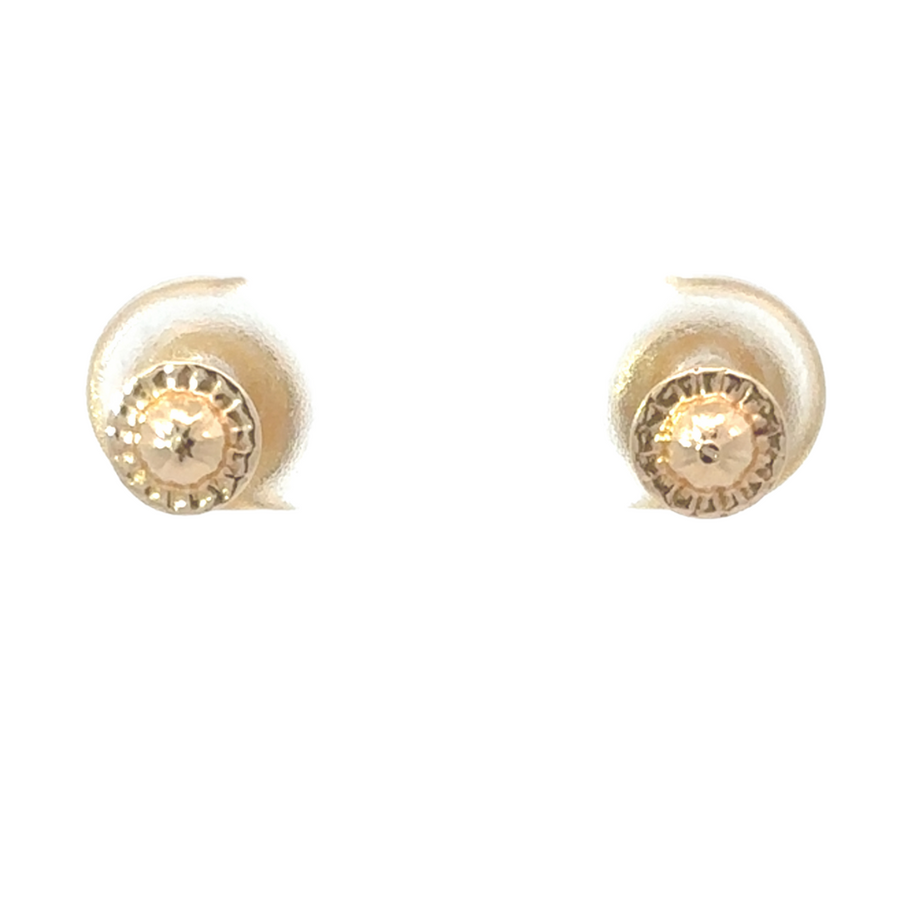 Elegant 14K gold red stone stud earrings on a model’s ear, adding a touch of sophistication to an outfit.
