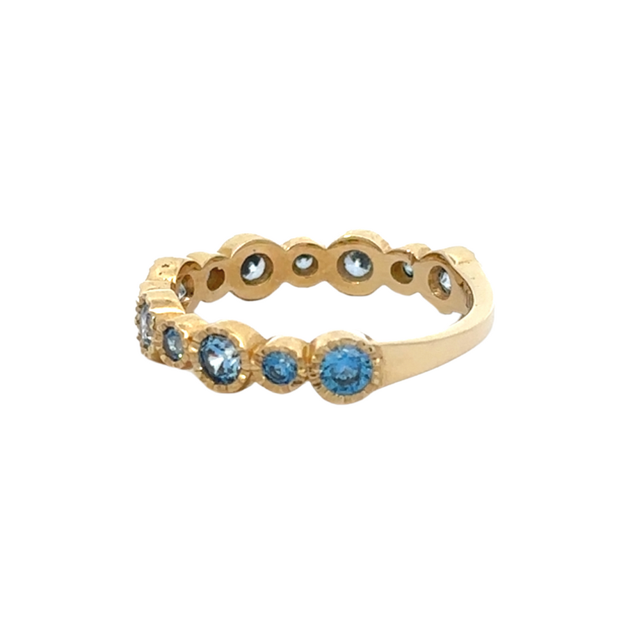 Side view of elegant 14K gold ring featuring blue CZ in circle setting