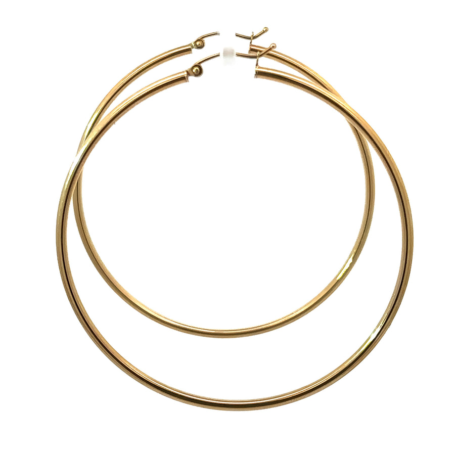 Woman wearing large 14k gold 60mm hoop earrings