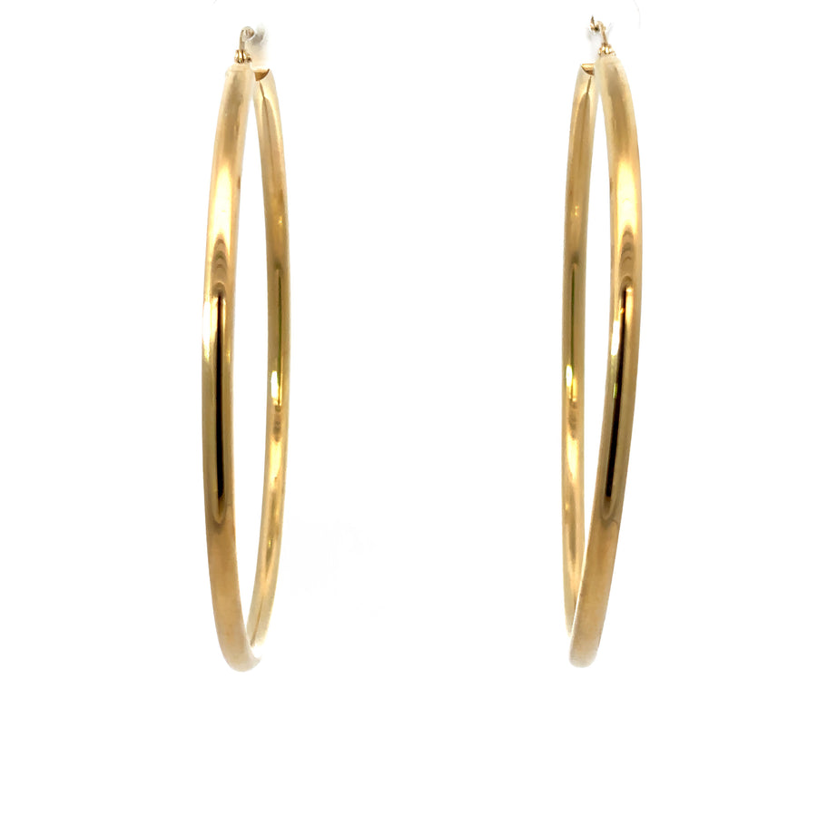 Close-up of large polished 14k gold hoop earrings for women