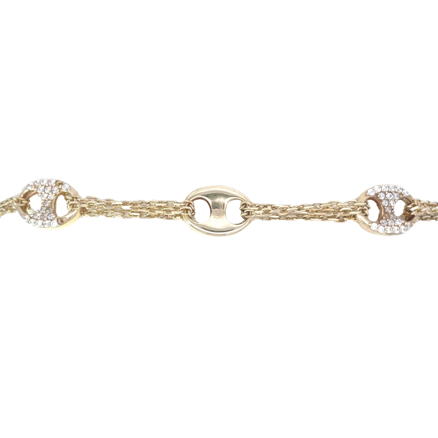 Woman modeling 14k gold bracelet with layered gold bangles