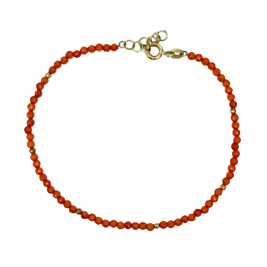 Close-up of orange stone on adjustable 14k gold bracelet
