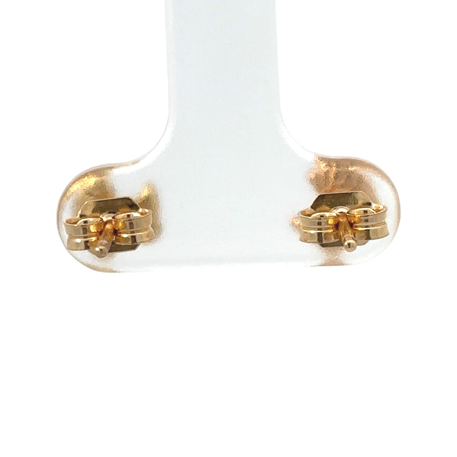 Baby wearing delicate 14k gold stud earrings