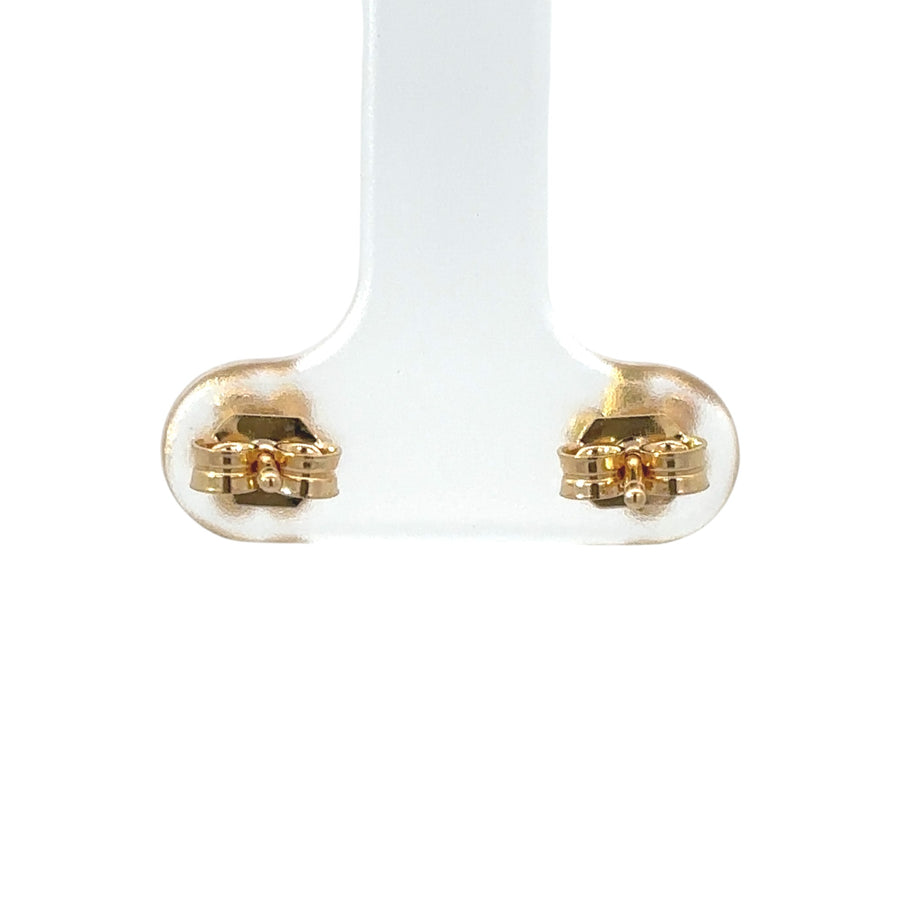 Baby wearing delicate 14k gold stud earrings