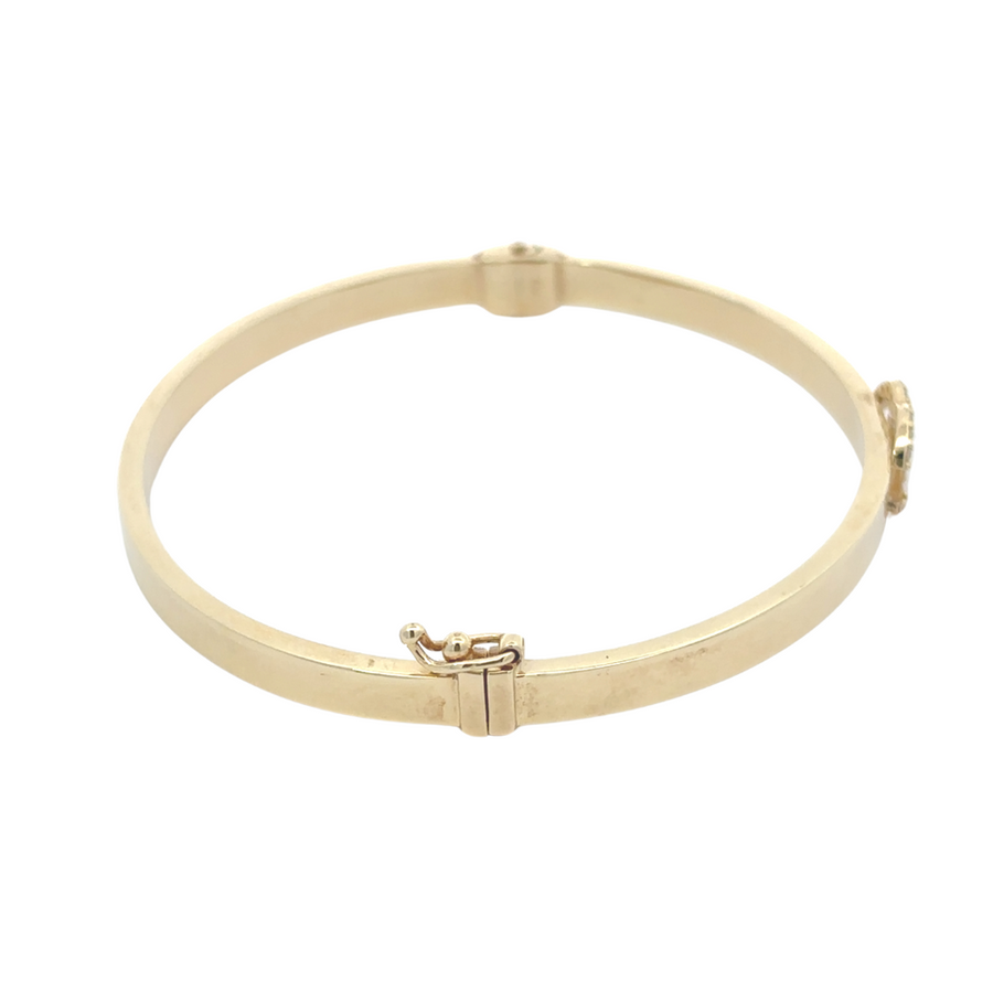 Elegant 14k gold unisex bangle placed on a white background
