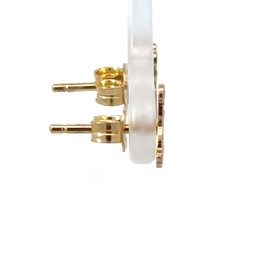 Baby wearing 14k gold bear earrings with secure backing