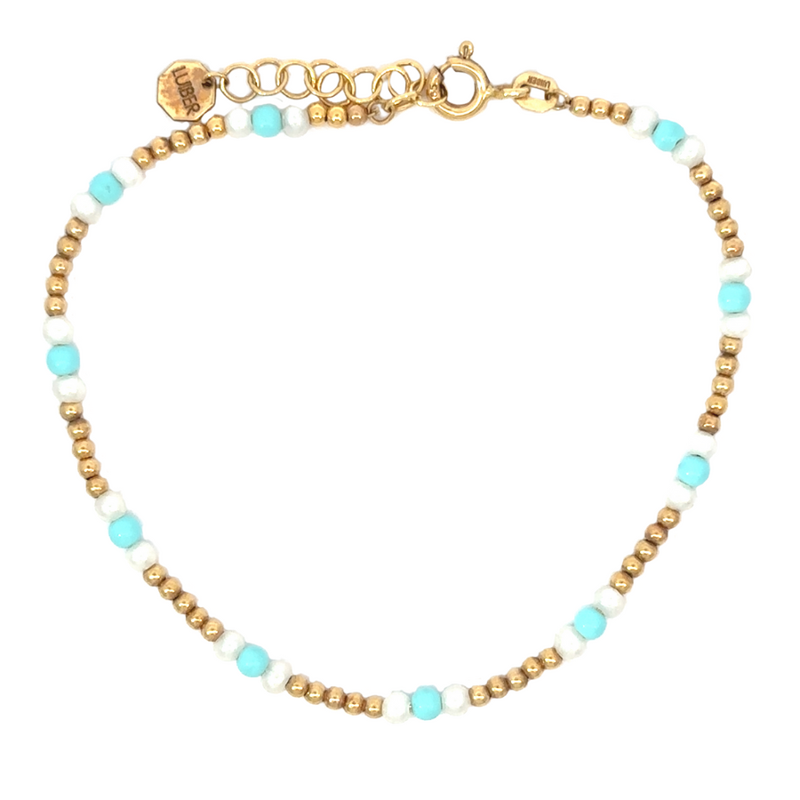 Close-up of 14k gold bracelet with pearl and turquoise accents on white background