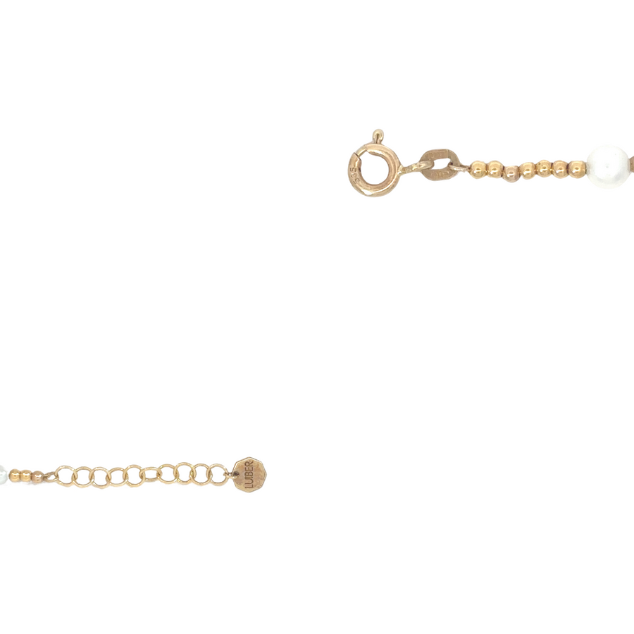 Woman wearing gold bracelet with pearl in daylight