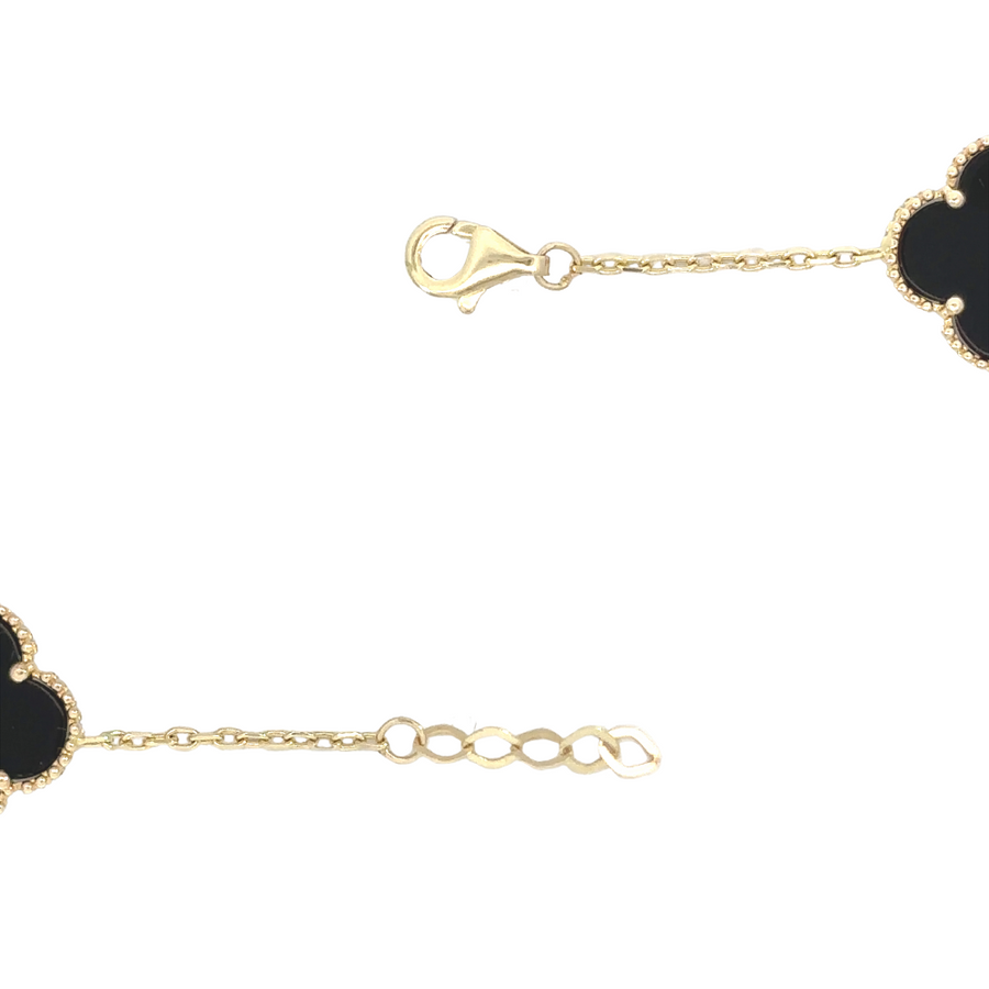 Top view of gold bracelet featuring five black gemstones