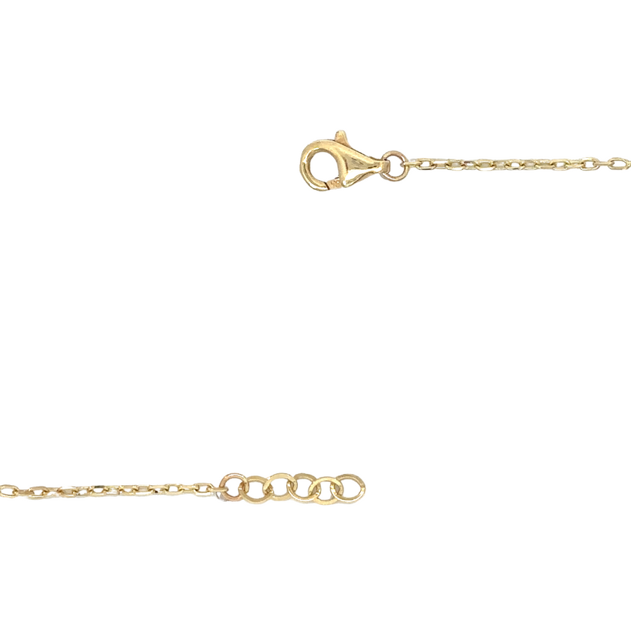 Gold bracelet with red accents draped over soft fabric
