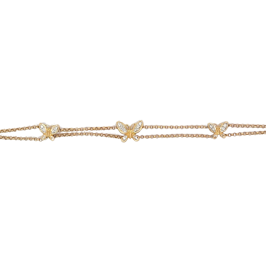 Macro shot of the butterfly charm detail, showcasing craftsmanship and gold shine.