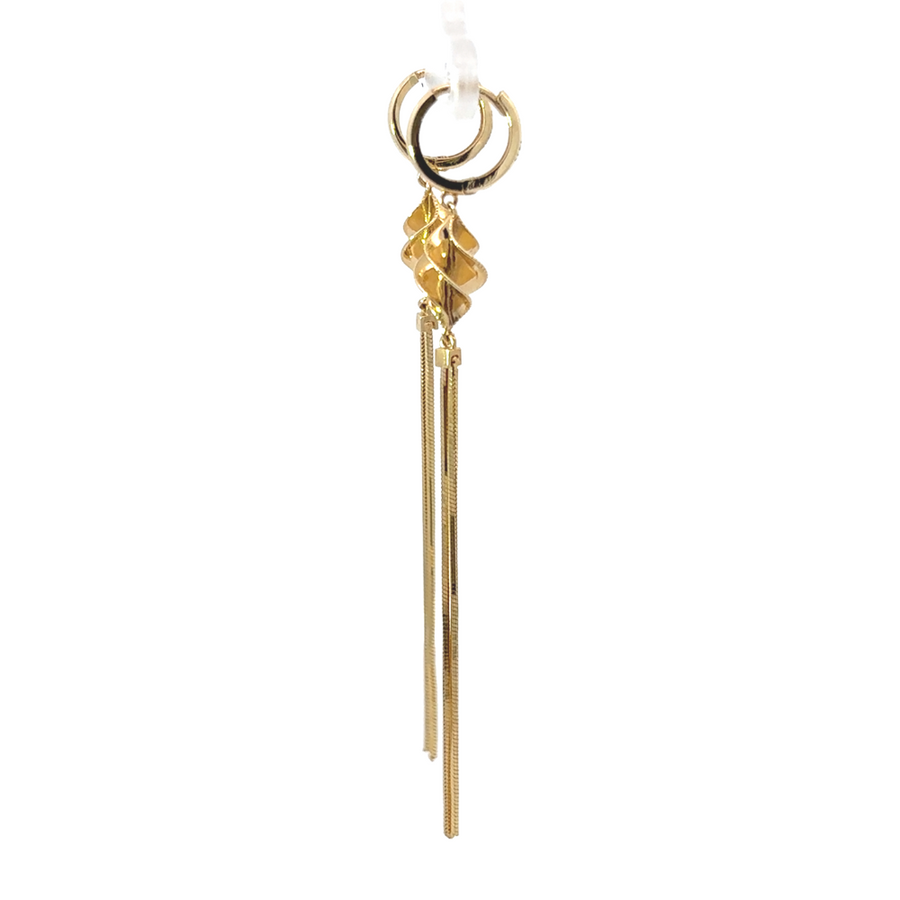 Woman wearing 14k gold dangle chain earrings with graceful movement, styled casually