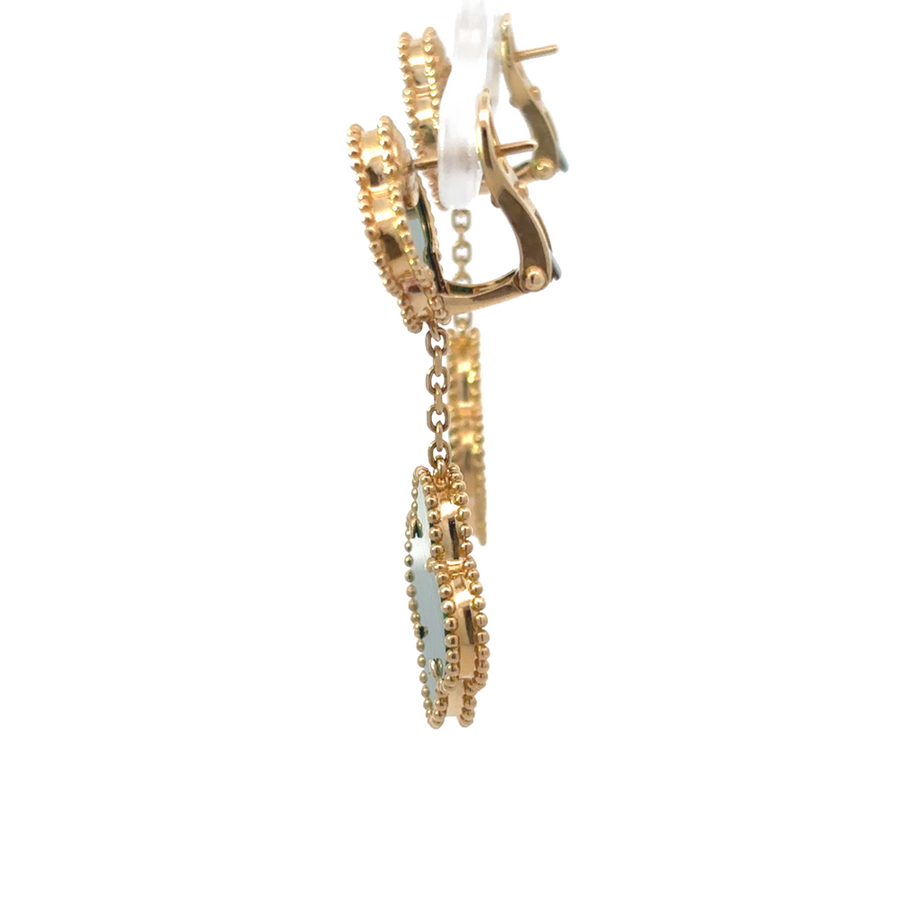 Pair of polished gold earrings displayed on neutral fabric