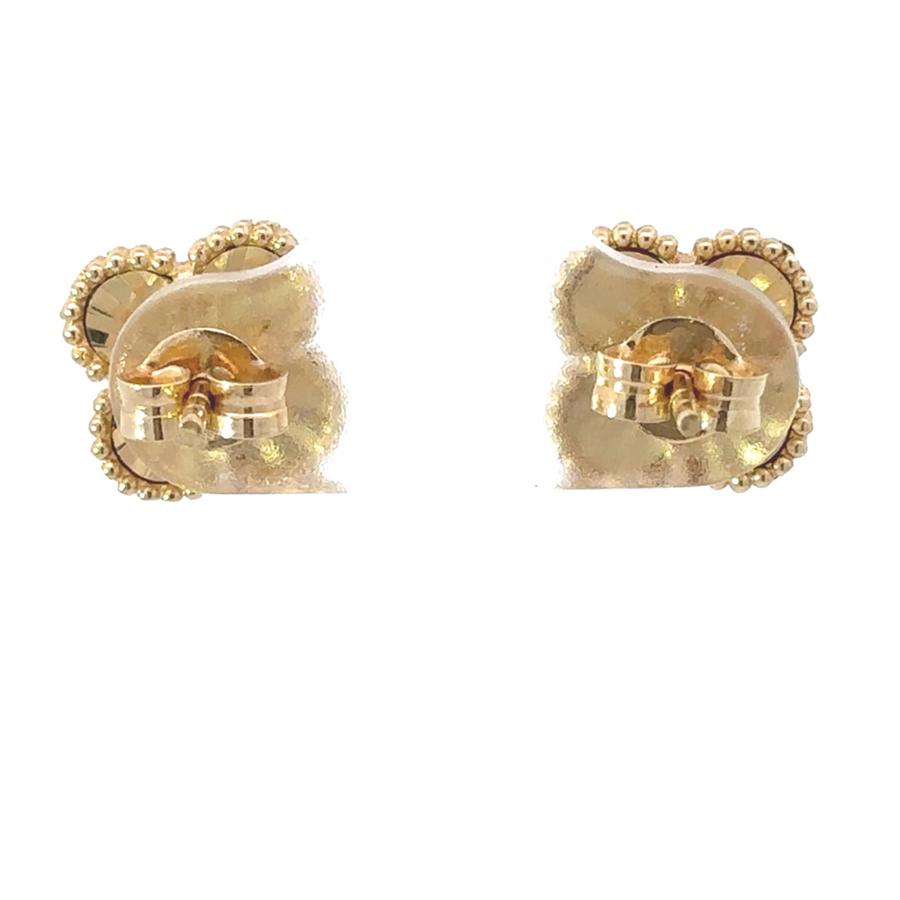Gold earrings resting on a velvet jewelry display
