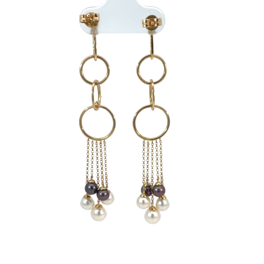 Close-up of 14k gold earrings showcasing diamond and pearl details