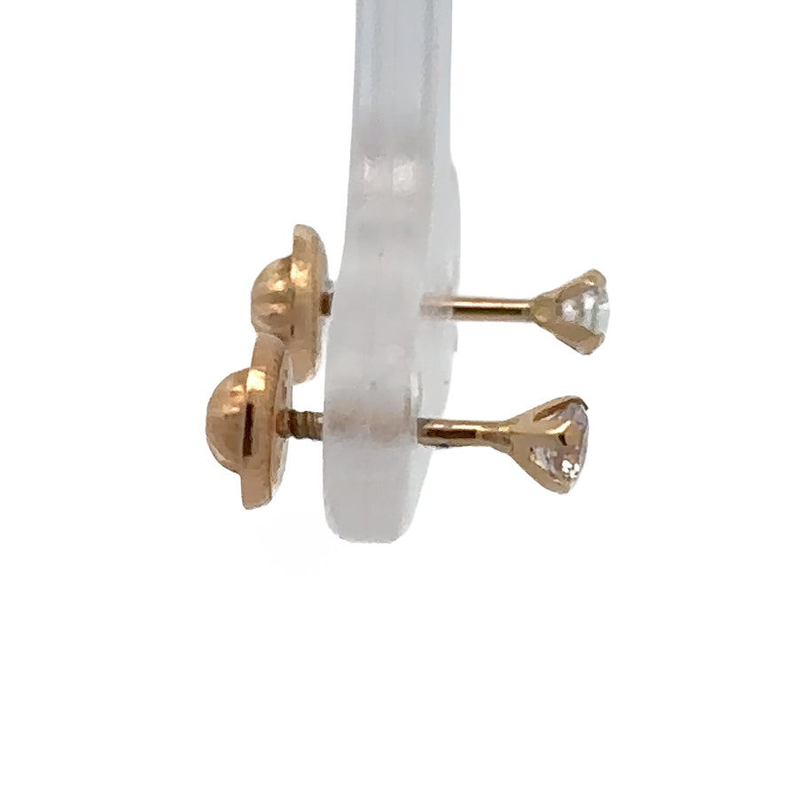 Tiny 14k gold studs on soft white background