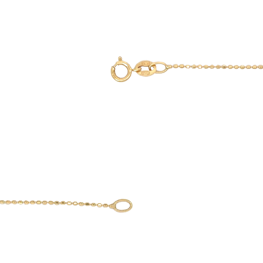 14k gold fancy necklace draped over a leather surface next to a watch