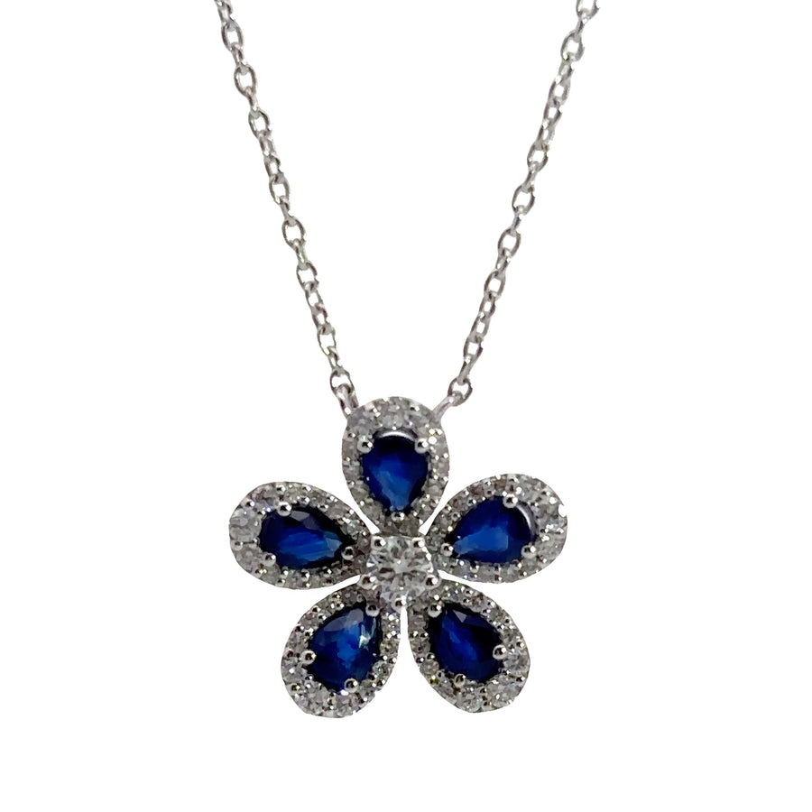 Close-up of floral pendant featuring diamonds and deep blue sapphire