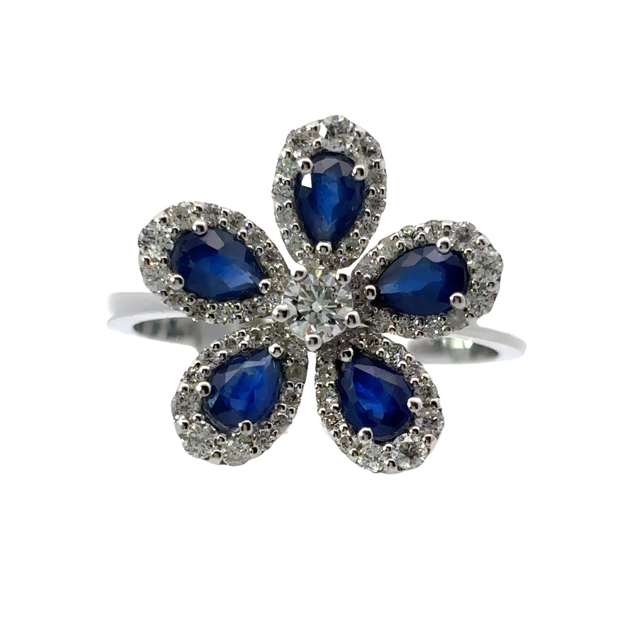 Close-up of floral ring featuring sparkling diamonds and blue sapphire