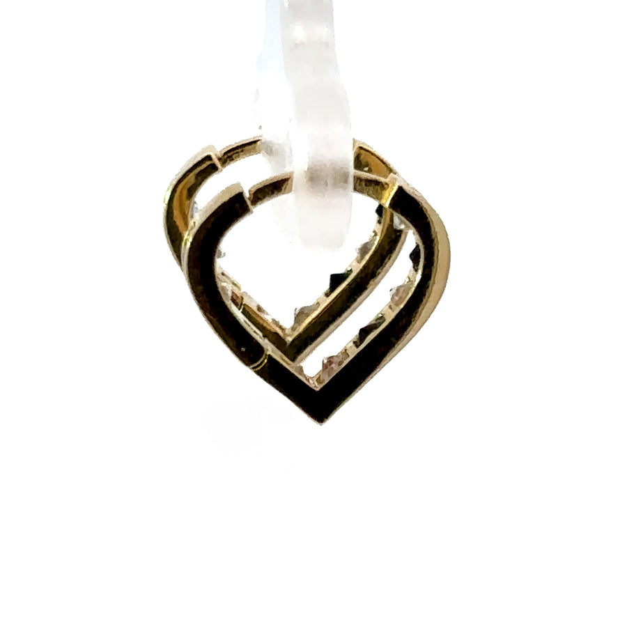 Close-up of baby gold heart huggie earrings with CZ stones