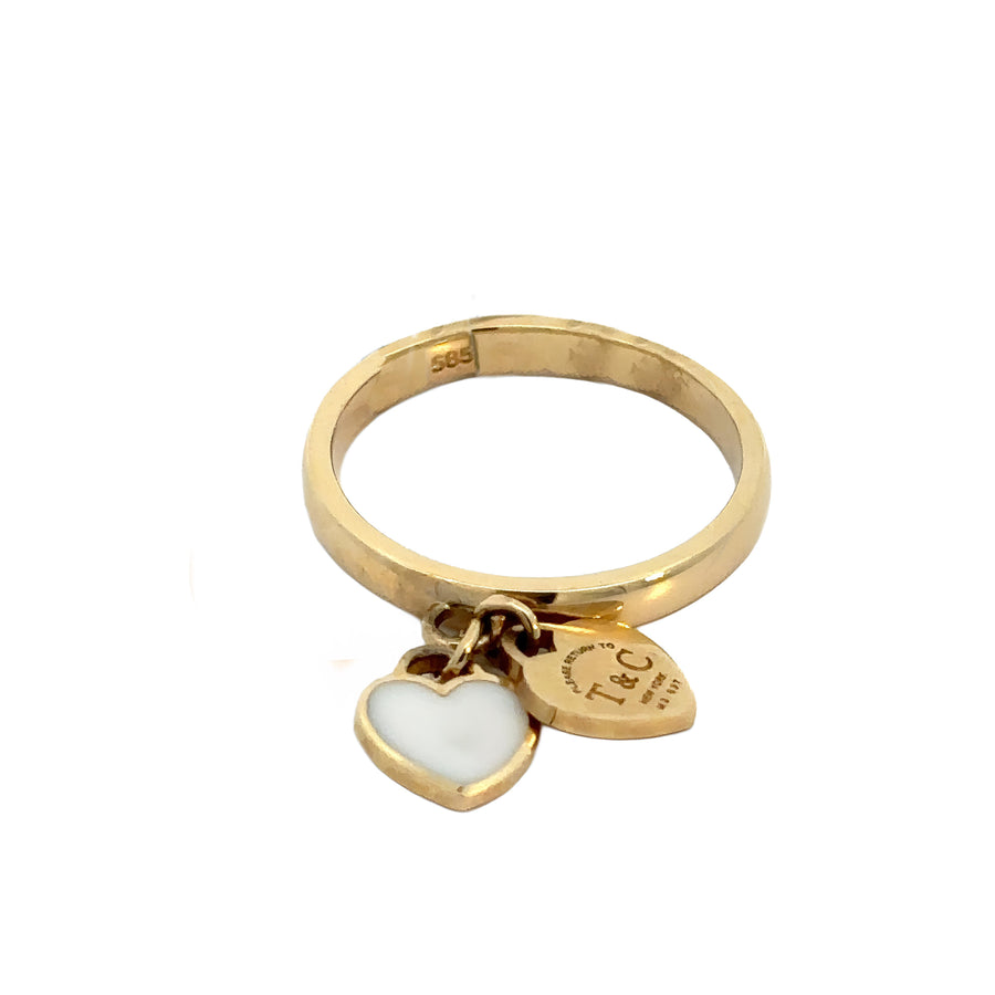 Close-up of delicate gold heart ring on finger