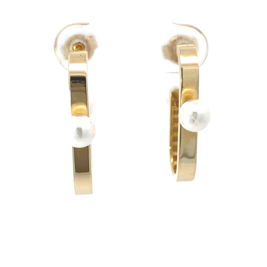 Close-up of 14k gold hoop earrings with a pearl accent, showcasing their elegant design