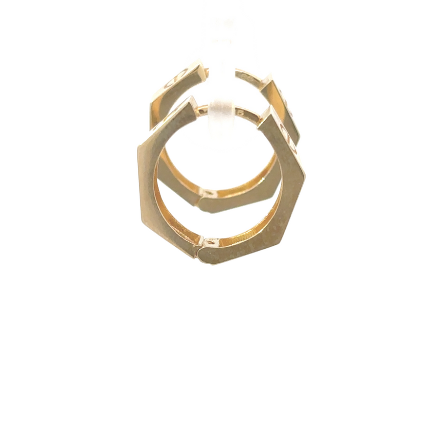 Woman wearing 14k gold huggie earrings, showcasing their minimal and elegant fit.