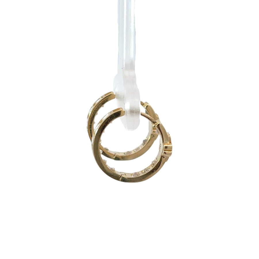Close-up of 14k gold huggie earrings featuring blue floral accents