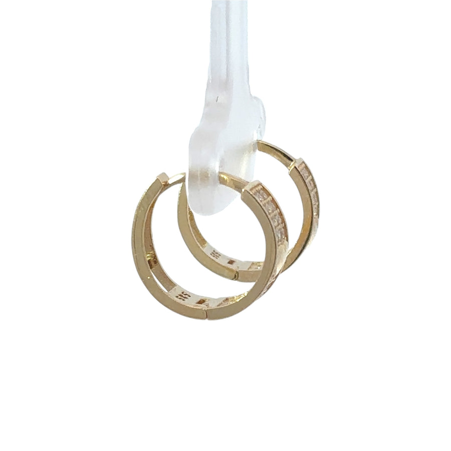 Close-up of polished gold heart on huggie-style earrings