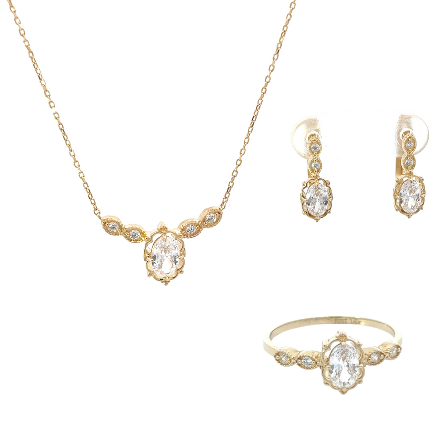 Close-up of 14k gold jewelry set with matching ring, necklace, and earrings featuring oval center stones.