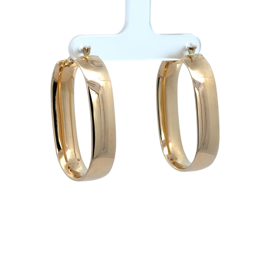 Close-up of large 14k gold earrings with polished finish

