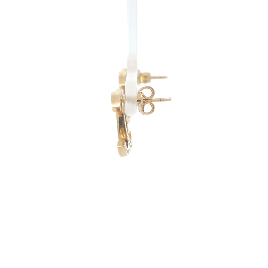 Side profile of a woman wearing 14k gold CZ earrings, showing their elegant drop and shine.