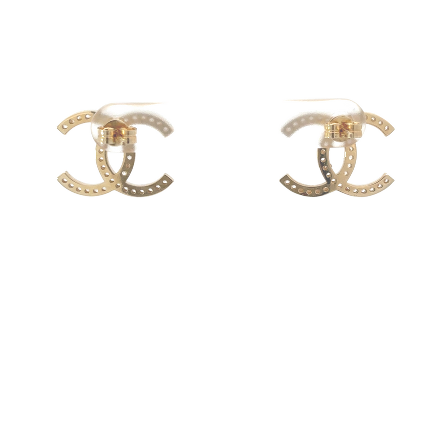 Flat-lay of the earrings with light reflecting off the CZ stones and polished gold.