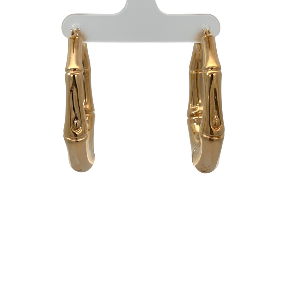 Woman wearing large 14k gold bamboo oval earrings