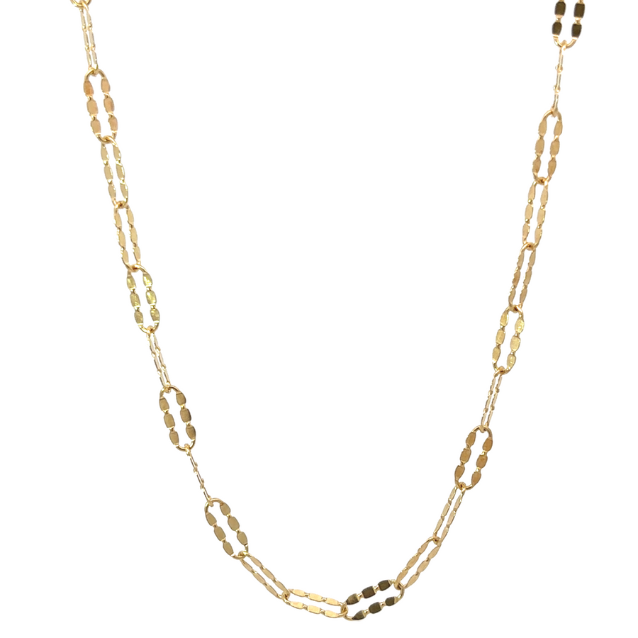 Elegant woman wearing 14k gold long shine chain layered with other necklaces