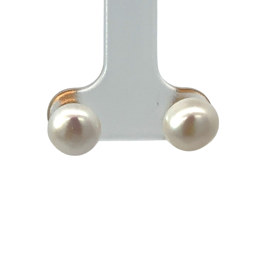 Close-up of 14k gold medium pearl earrings on white background