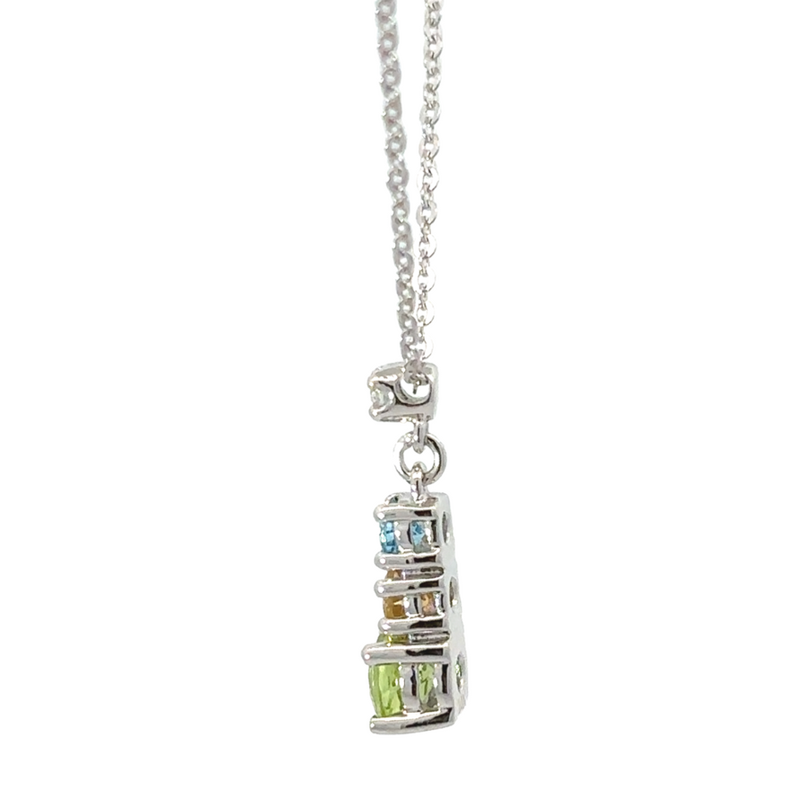 Woman wearing 14k gold topaz necklace with a white blouse