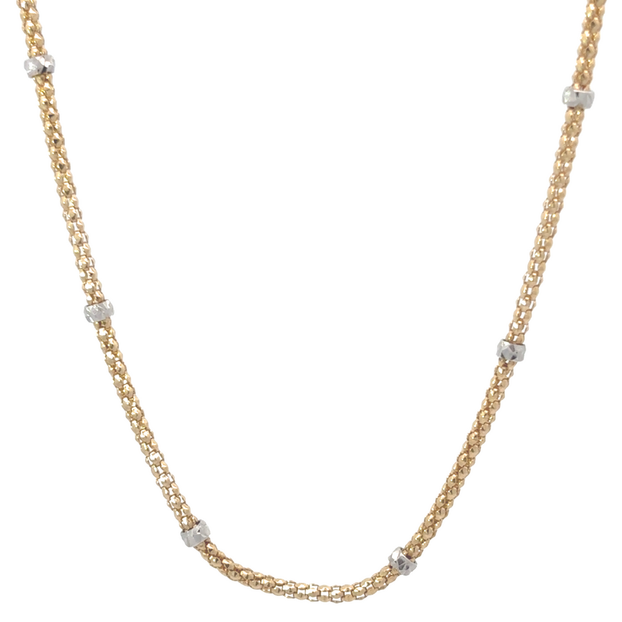 Close-up of two-tone 14k gold necklace featuring white gold balls