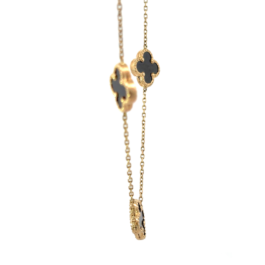 Woman wearing 14k gold necklace with nine black stones styled with a chic outfit