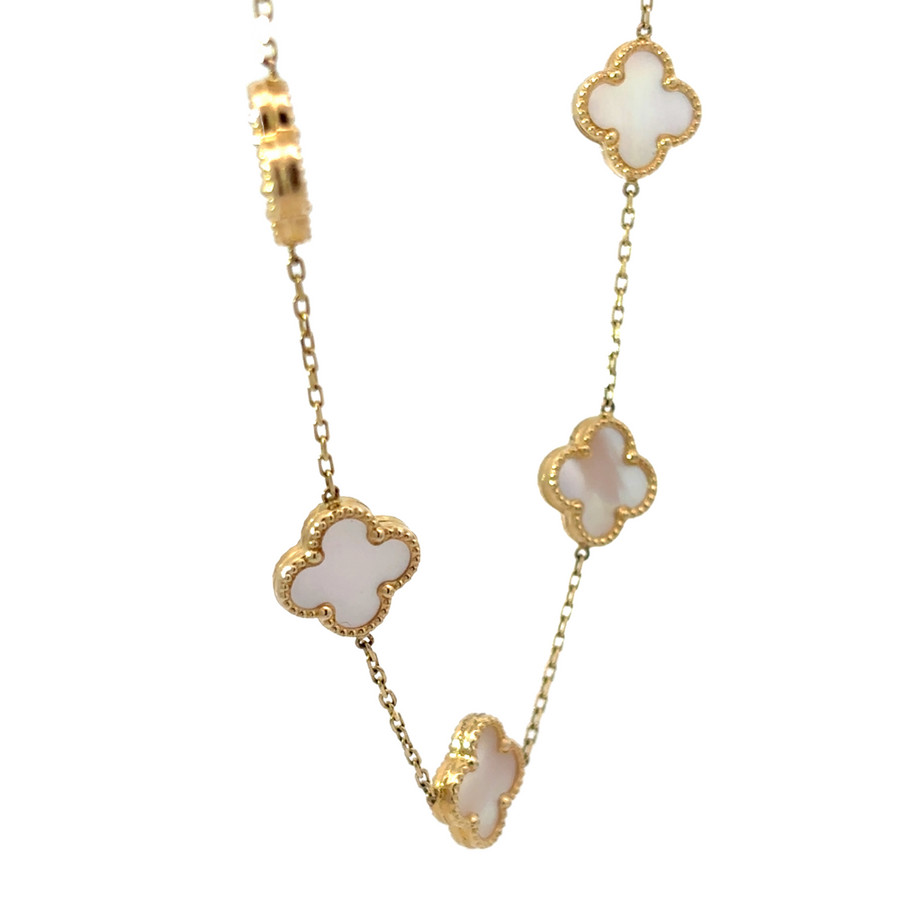 Flat-lay view of 14k gold necklace with 9 sparkling white stones