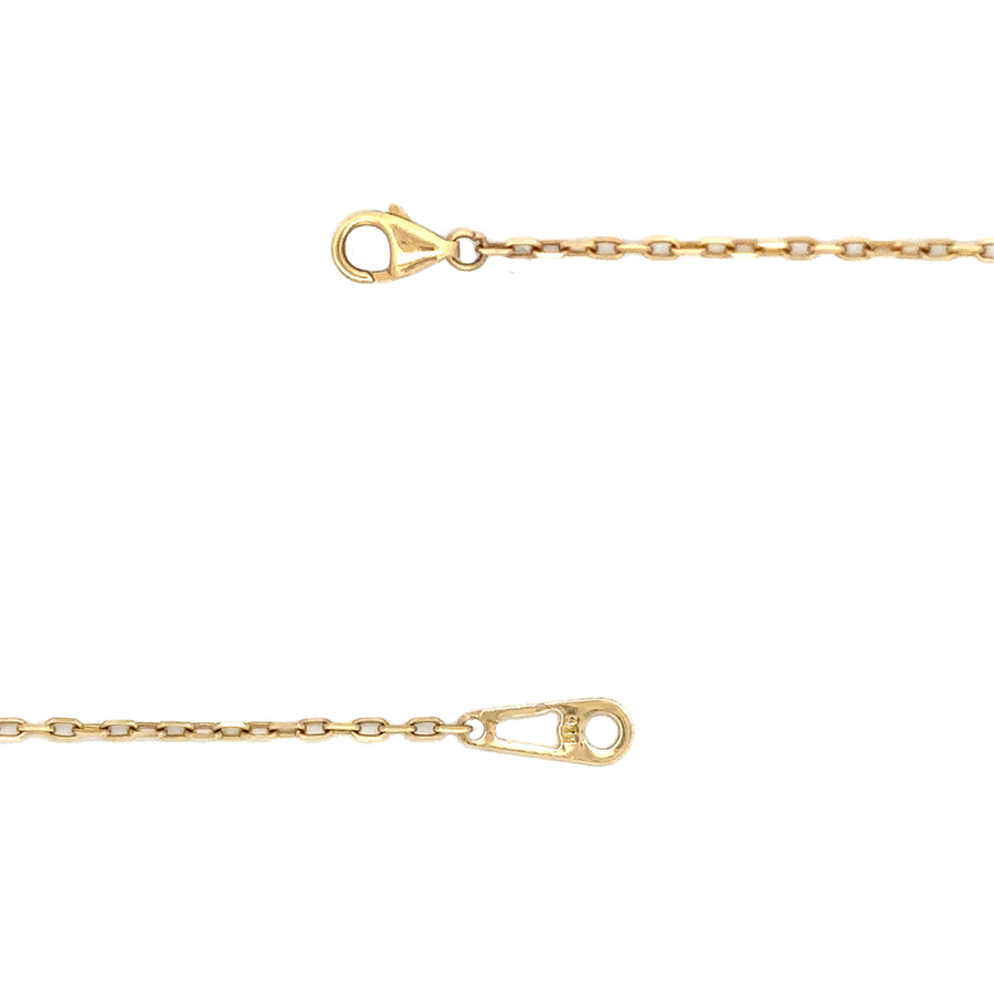 Woman wearing 14k gold necklace with nine white stones against a soft fabric