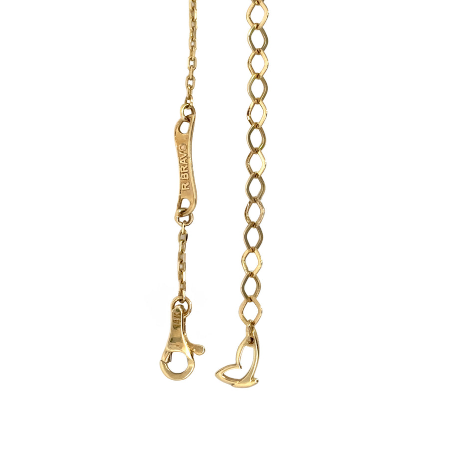 Woman wearing 14k gold necklace with blue cube details