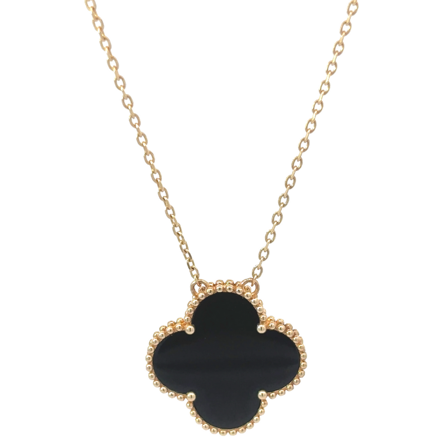 Close-up of 14k gold necklace with black center accent on white background
