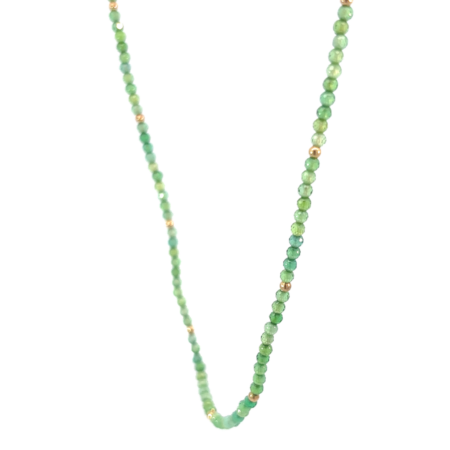 Elegant gold necklace with green corundum on white background