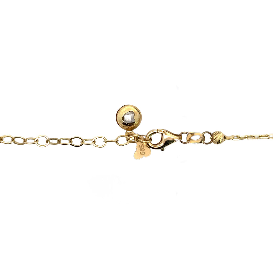 Close-up of green and glitter balls on gold necklace