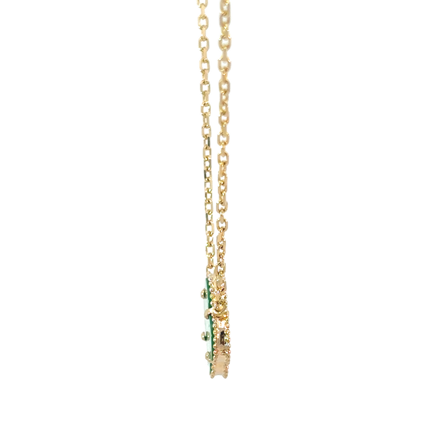 Model wearing 14k gold necklace with emerald-green pendant