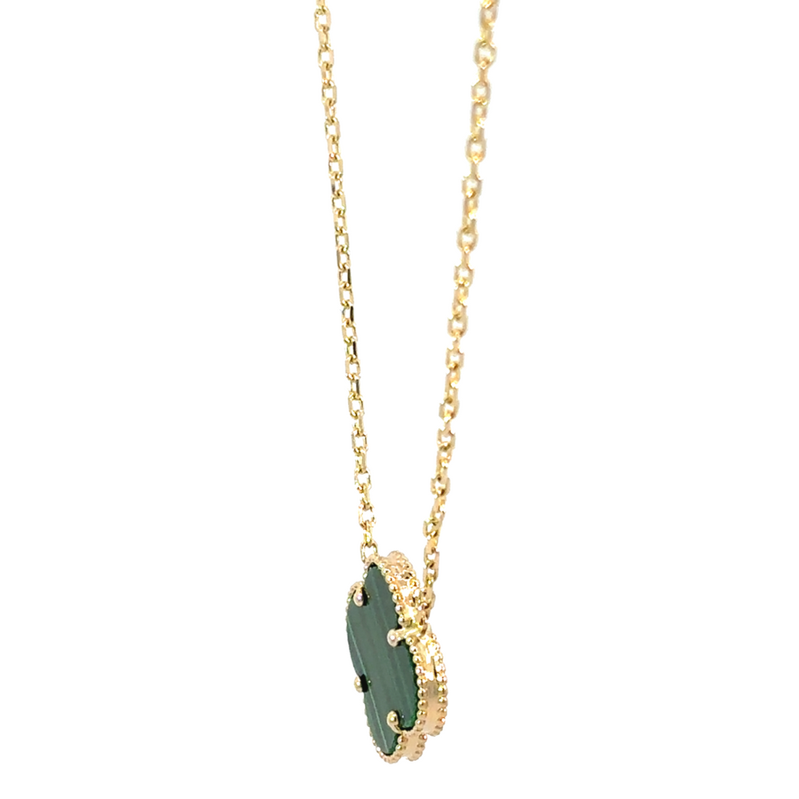 Elegant 14k gold chain with green pendant draped on fabric