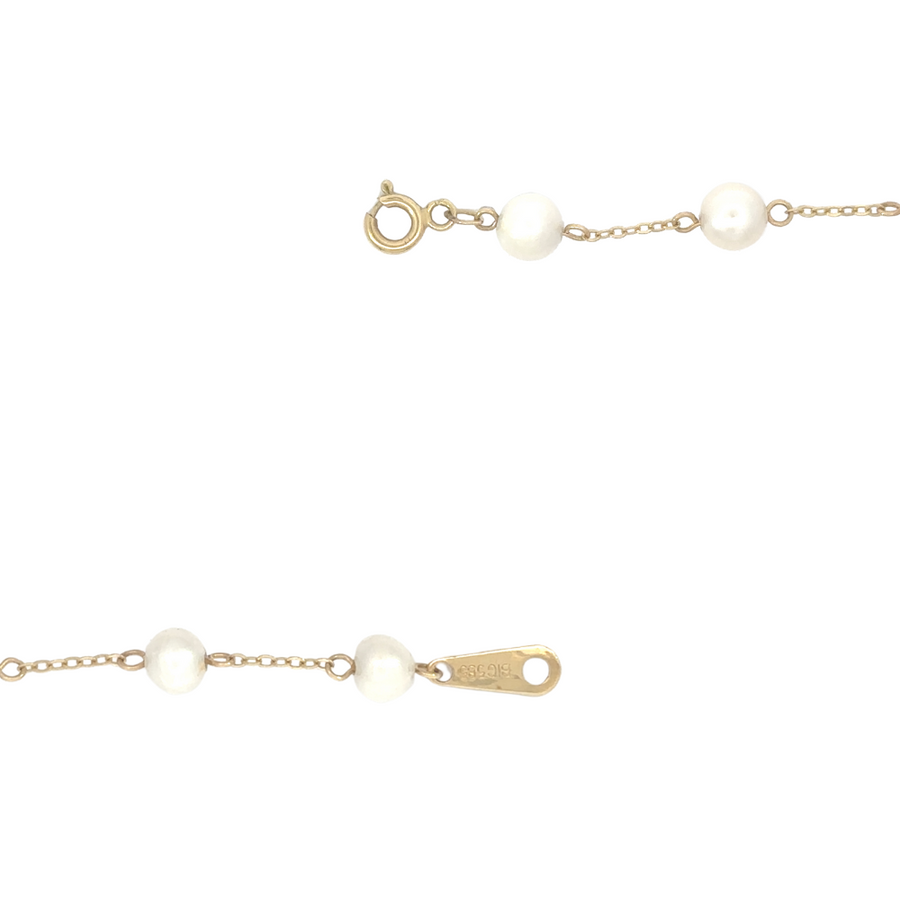 Gold and pearl necklace laid flat to showcase full design